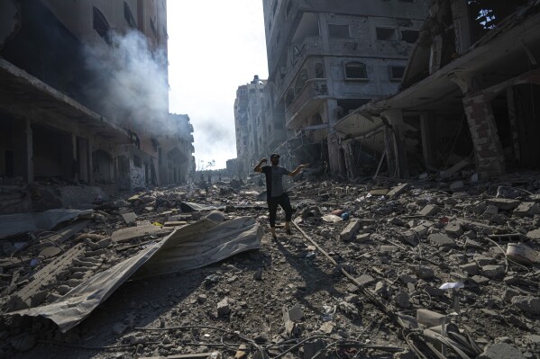 A Palestinian walks through the destruction by Israeli bombing in Gaza City on Wednesday, Oct. 11, 2023. (AP Photo/Fatima Shbair)